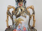 a vase with a painting on it sitting on a table
