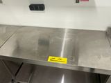 une table en acier inoxydable sur laquelle est posée une étiquette jaune