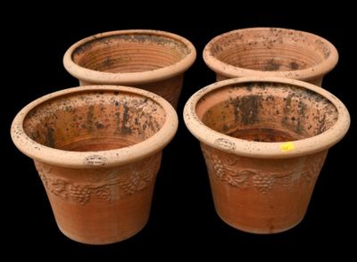 four clay pots are lined up in a row on a black background