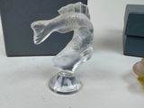 a glass figurine of a fish on a table