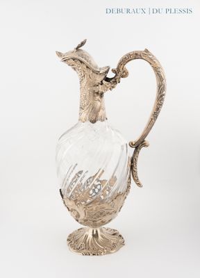a silver and glass vase with a bird on top of it