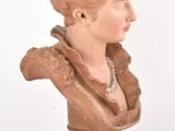 a clay bust of a woman with a flower crown on her head