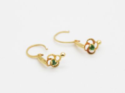 pair of gold earrings with green stones on white background