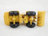 a yellow toy tractor that is sitting on a white surface
