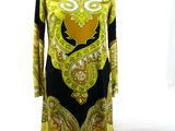 yellow and black dress on a mannequin stand in front of a window
