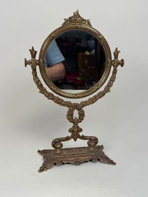 a small mirror on a stand with a man in the background