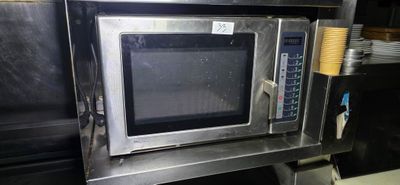 a microwave that is sitting on a shelf in a kitchen