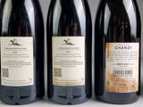 three bottles of wine are lined up on a table