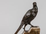 une statue représentant un oiseau perché sur un bloc de bois
