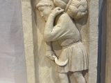 pair of stone reliefs of a woman carrying a basket of fruit