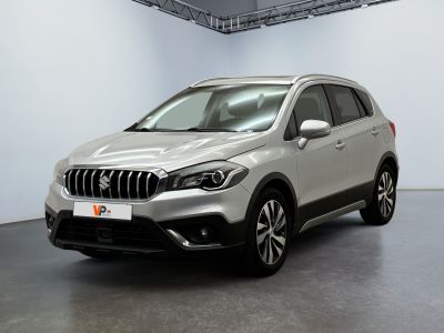 Le SUV argenté est garé dans une pièce blanche au sol noir.