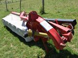 a red tractor that is sitting in the grass