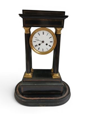 a black and gold clock sitting on a white surface