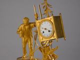 une horloge en or sur laquelle figurent un homme et une femme