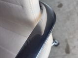 a close up of a white chair with a black arm rest