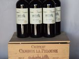 quatre bouteilles de vin se trouvent dans une caisse en bois posée sur une table