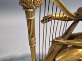 a statue of a woman playing a harp with a bird on it