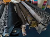 many rolls of fabric on a table in a room