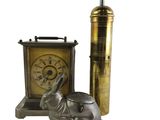 une petite statue d'éléphant à côté d'une horloge et d'un briquet