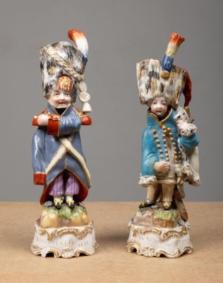 two figurines of a boy and a girl dressed in military clothing