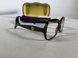 glasses are sitting on a table next to a purple case