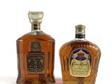 deux bouteilles de whisky Crown Royal posées côte à côte sur une surface blanche
