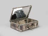 a small silver box with a mirror inside of it