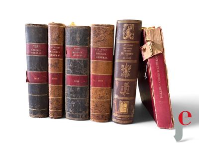 several old books are lined up in a row on a white surface