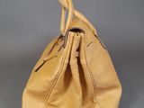 tan leather handbag on grey background
