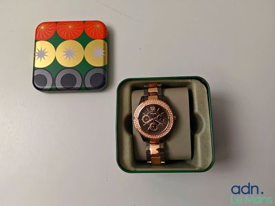 une montre dans une boîte, à côté d'une boîte sur laquelle est représentée une montre
