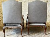 two chairs sitting next to each other on a brick floor