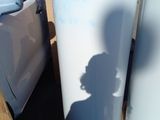 un réfrigérateur blanc posé sur une palette à côté d'une camionnette blanche