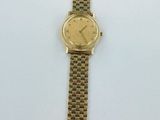 a close up of a gold watch on a white surface