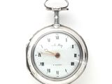 une montre de poche en argent avec des chiffres romains sur le cadran