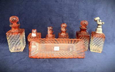 five bottles of perfume sitting on a blue surface