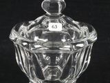 un saladier en verre transparent muni d'un couvercle, posé sur une surface noire