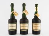 trois bouteilles de vin posées les unes à côté des autres sur une surface blanche