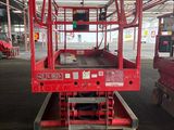 a picture of a red scissor sitting in a warehouse