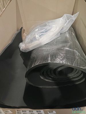 un rouleau de film alimentaire posé sur une boîte en carton