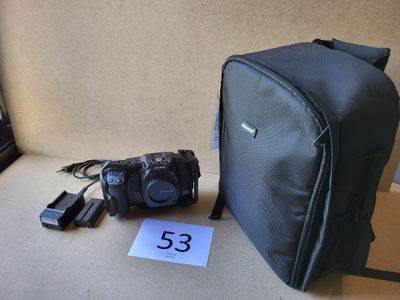 un appareil photo et un sac posé par terre à côté