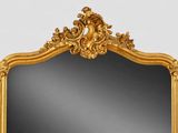 a gold framed mirror on the wall in the room