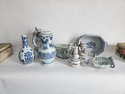 a white table topped with blue and white vases and dishes