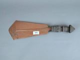 une spatule en bois avec un manche en métal posée sur une surface grise
