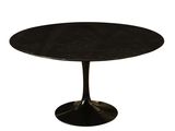 une table ronde en marbre noir avec un piètement noir