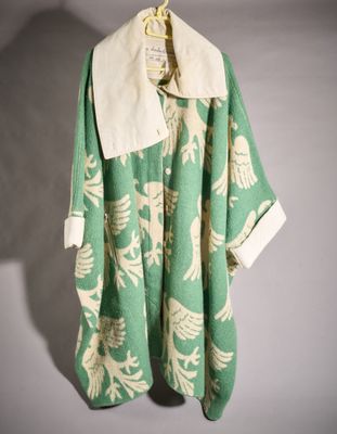 une photo d'un manteau vert et blanc suspendu à un cintre
