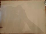 a shadow of a person on a piece of paper on the floor