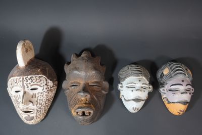 four african masks are lined up against a black background