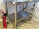 a metal table with a red fire extinguisher next to it
