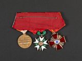 an image of a red ribbon with a gold medal and a silver medal