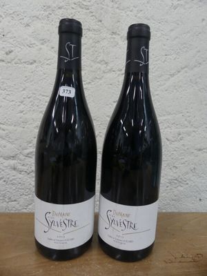 deux bouteilles de vin posées sur une table en bois